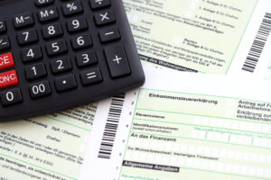 German Annual Income Tax Return Declaration And Calculator Lies On Accountant Table Close Up. The Concept Of Taxpaying Period In Germany - Escritório de Contabilidade em São Paulo | Revicont Contabilidade